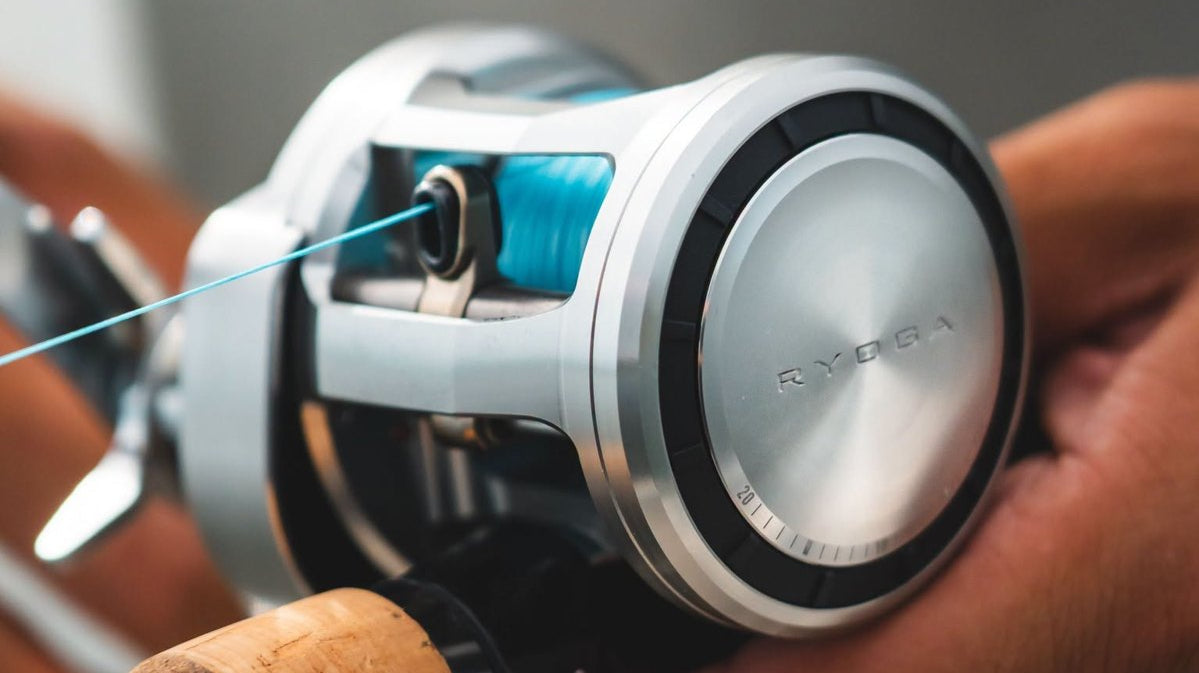 Angler holding a rod fitted with a round baitcasting reel