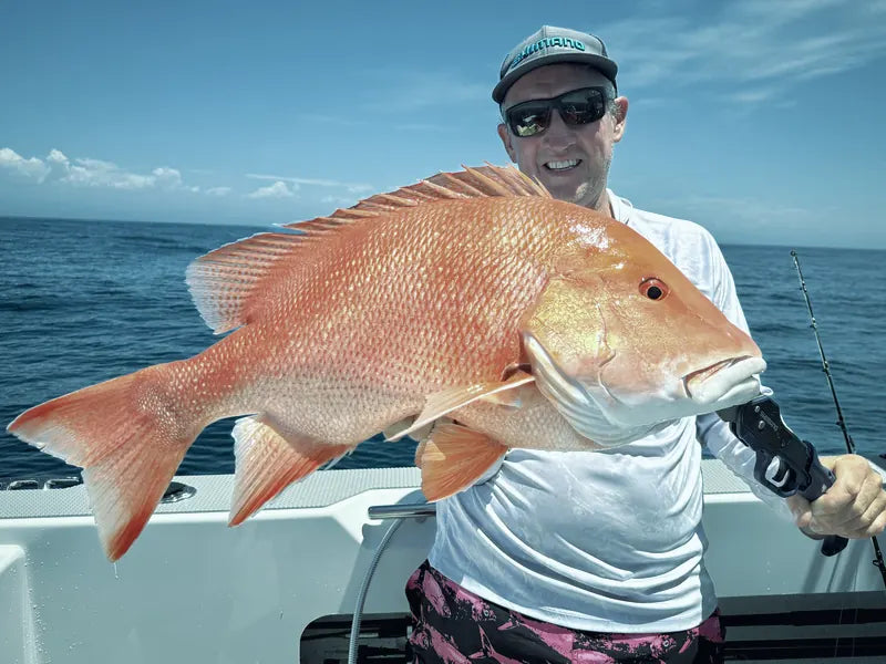 Angler holding a red emperor on a boat