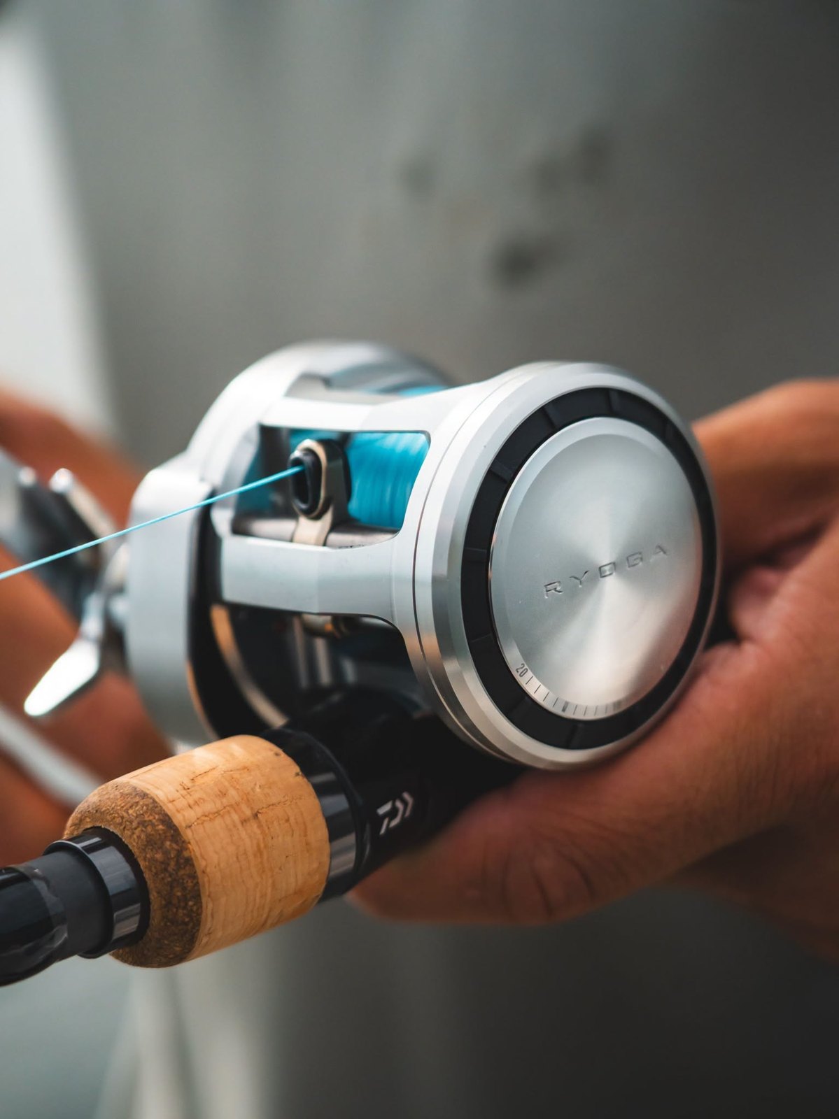Angler holding a rod fitted with a round baitcasting reel